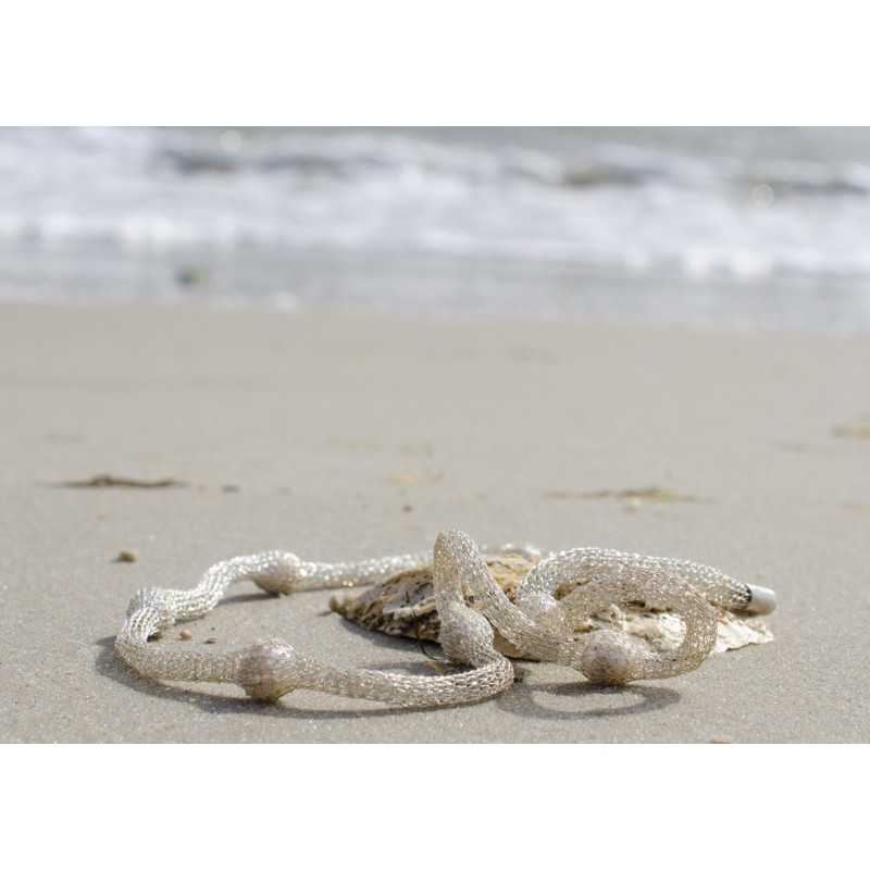 Fast wie in ihrer natürlichen Umgebung: Perlen am Strand - gut eingepackt im Silberschlauch: So trägt man heute Perlen.